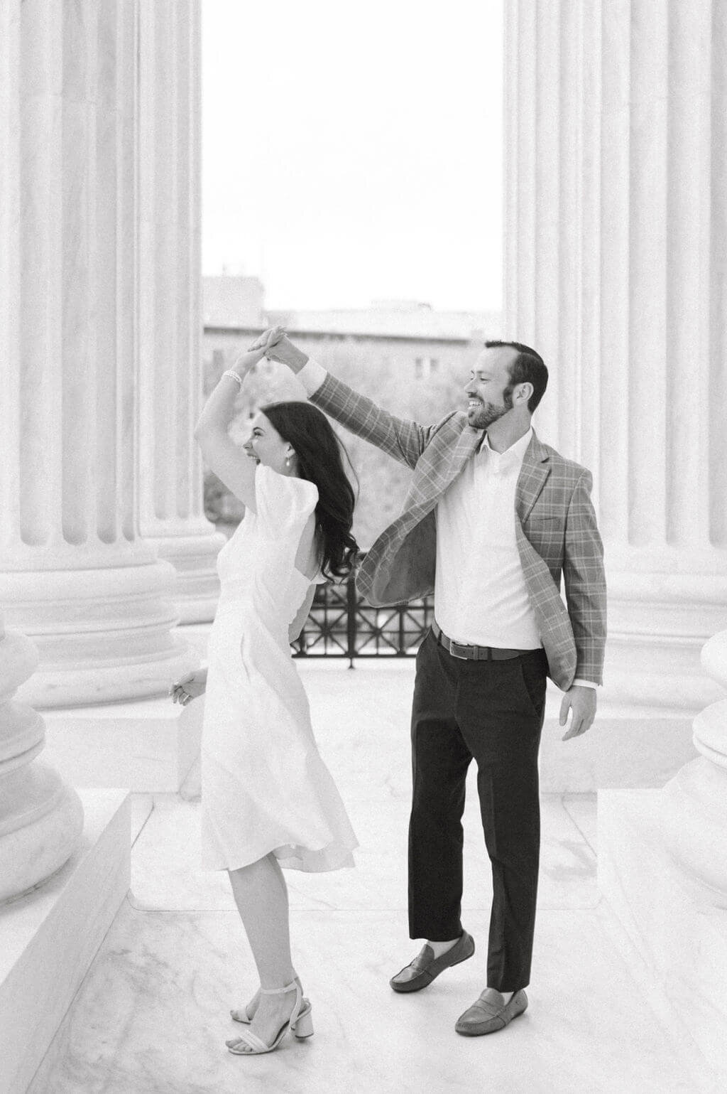 B&W image of a couple dancing together in between columns at the US Supreme Court