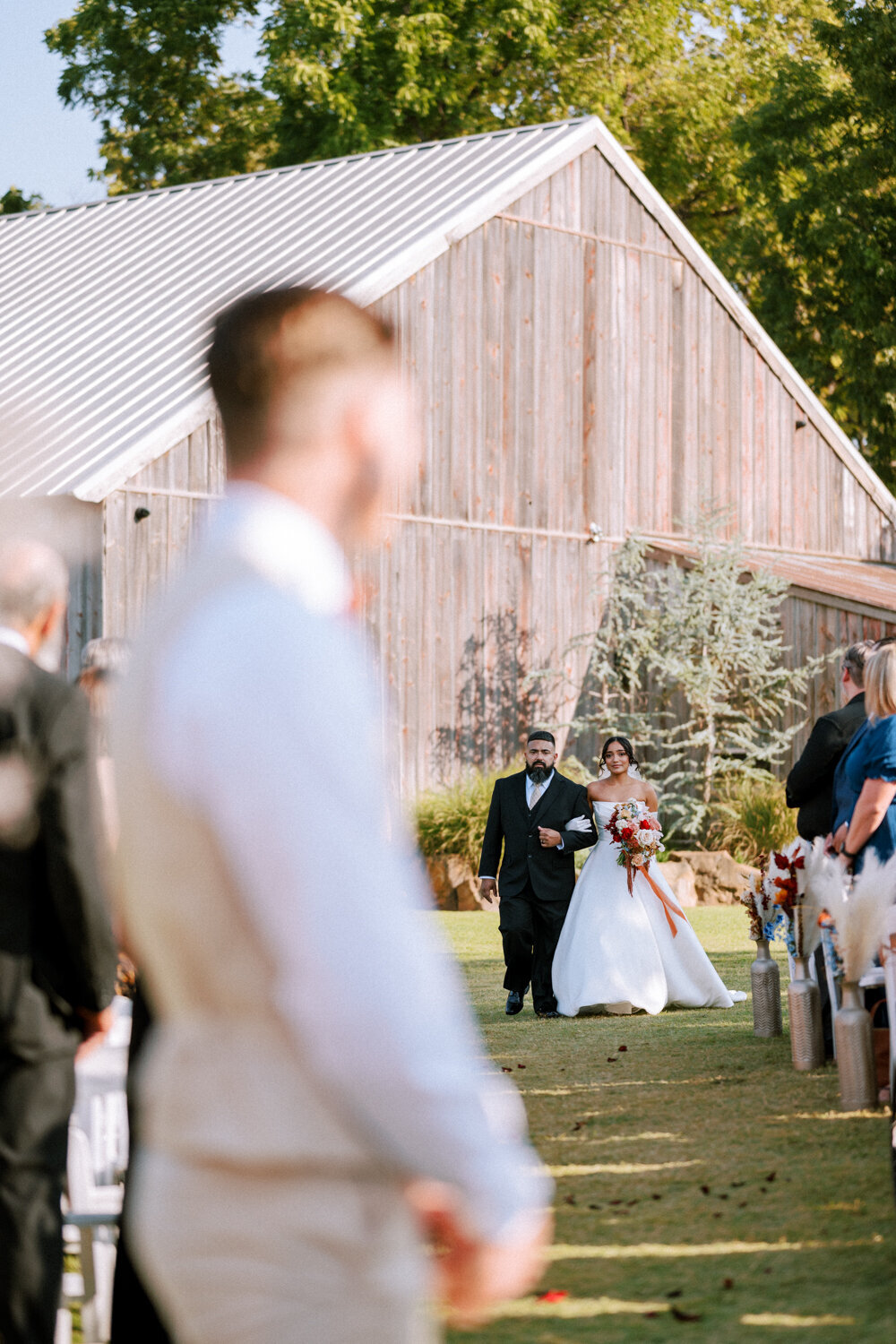 groom-watches-bride-and-dad-approaching-down-aisle