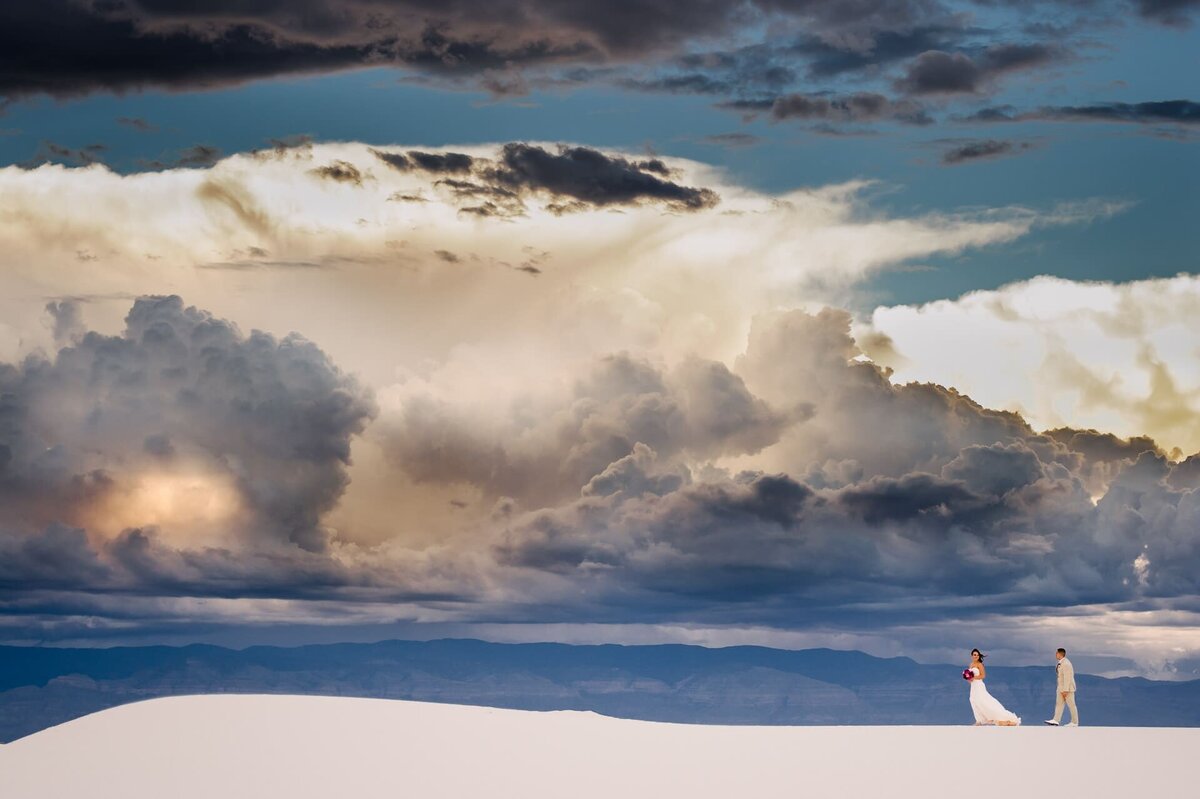 bride and groom walking on dunes at white sands  national park