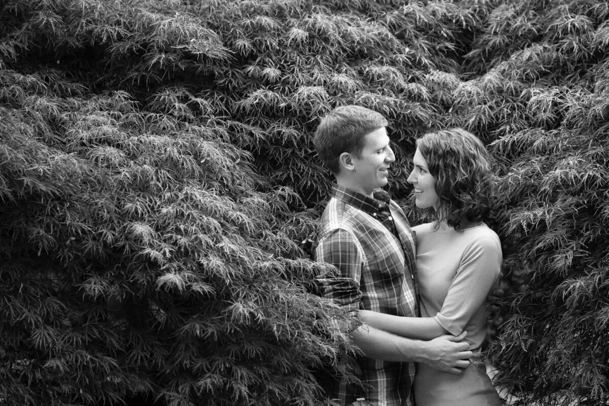 Black and white image of a couple embraced in a lush garden
