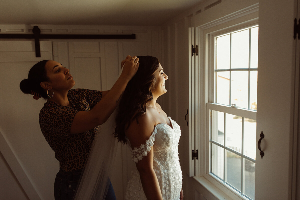 Stylist-putting-veil-on-bride