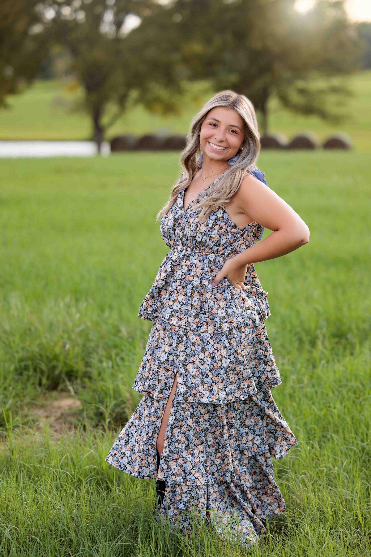 Raleigh Senior in a field wearing a long dress for senior portraits.