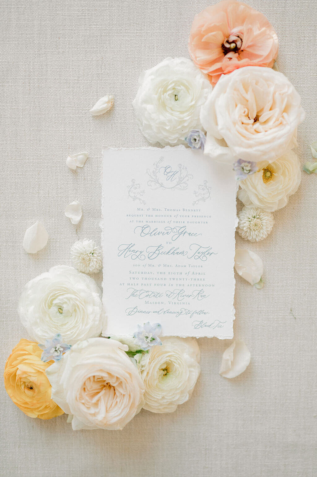 Wedding invitation surrounded by wedding florals for wedding flatlay photography