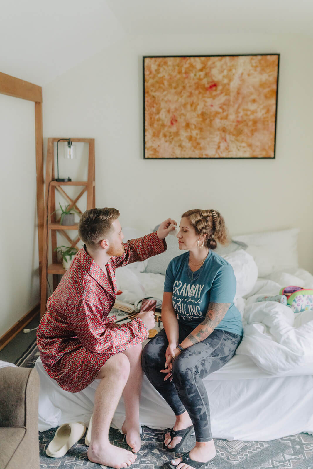 Man helping woman fix hair before finger lakes wedding, NY