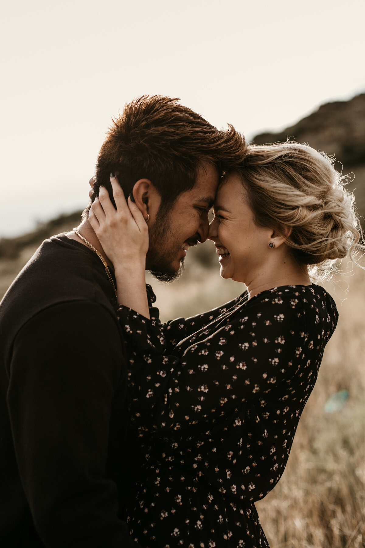 engaged couple holding each other laughing