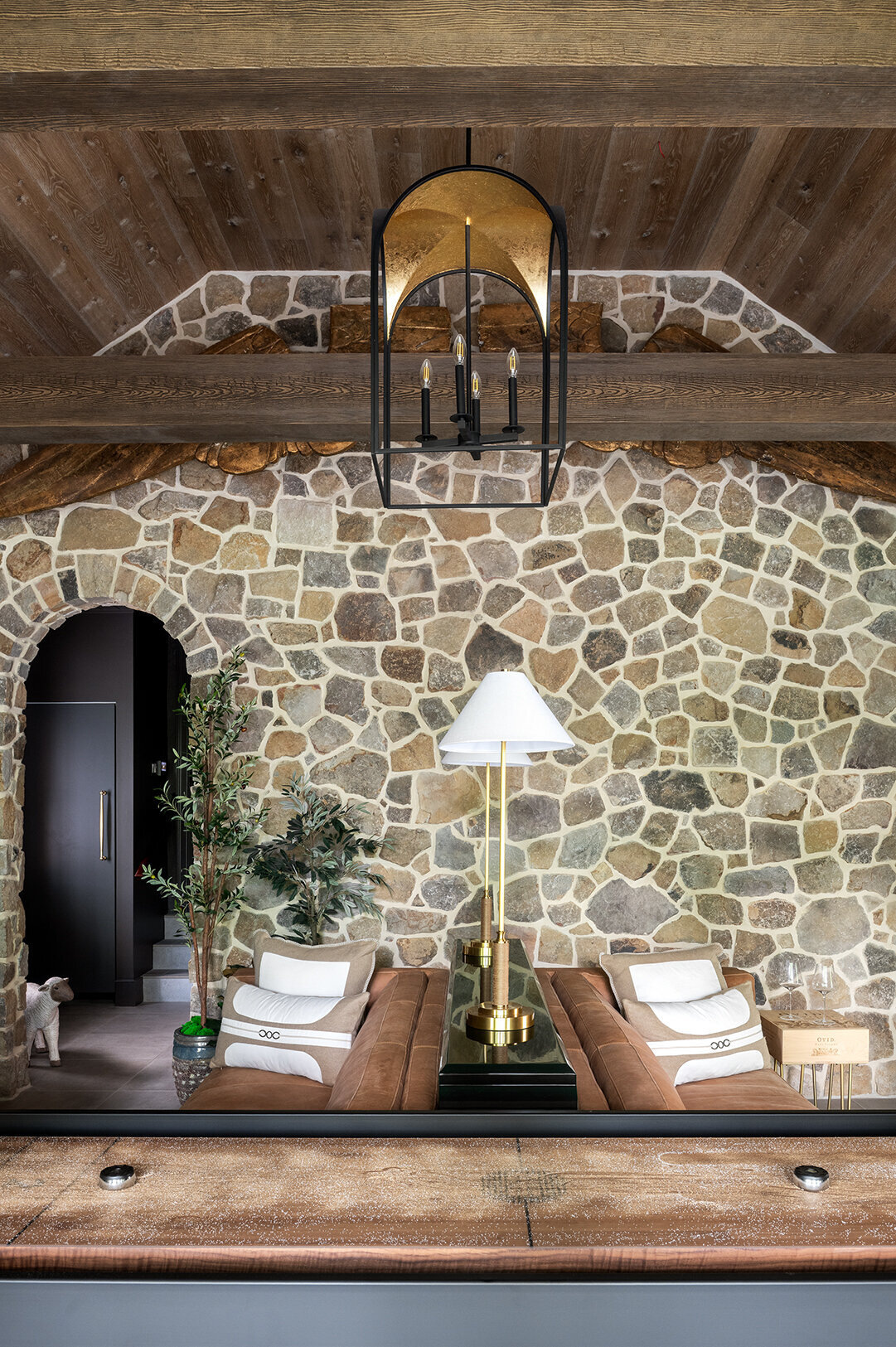 lounge room with stone wall, and open beam