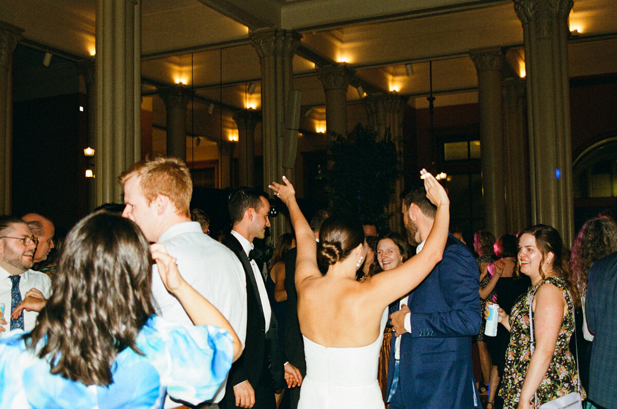 bride with her hands in the air at her minnesota wedding reception