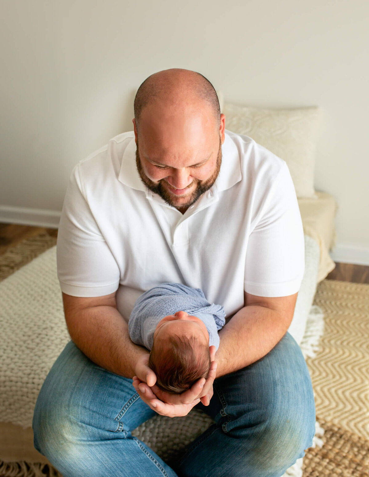 A dad smiles at his newborn baby boy during a portrait session with an Asheville Newborn Photographer