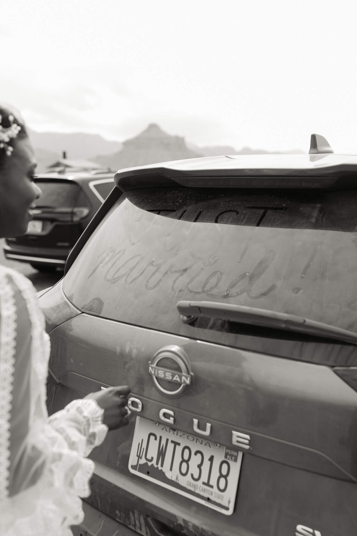 couple writes just married in the dust on their car