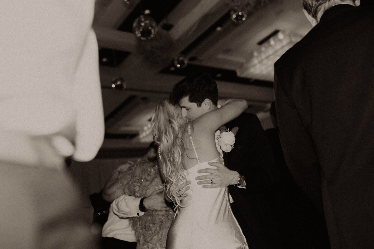 Wedding photographer, black-and-white bride, and groom dancing