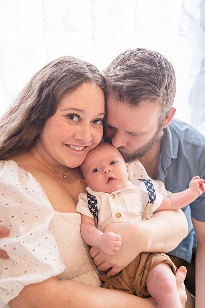 mom smiling with dad and newborn boy