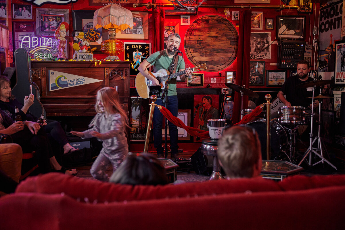 A person playing on stage at a bar