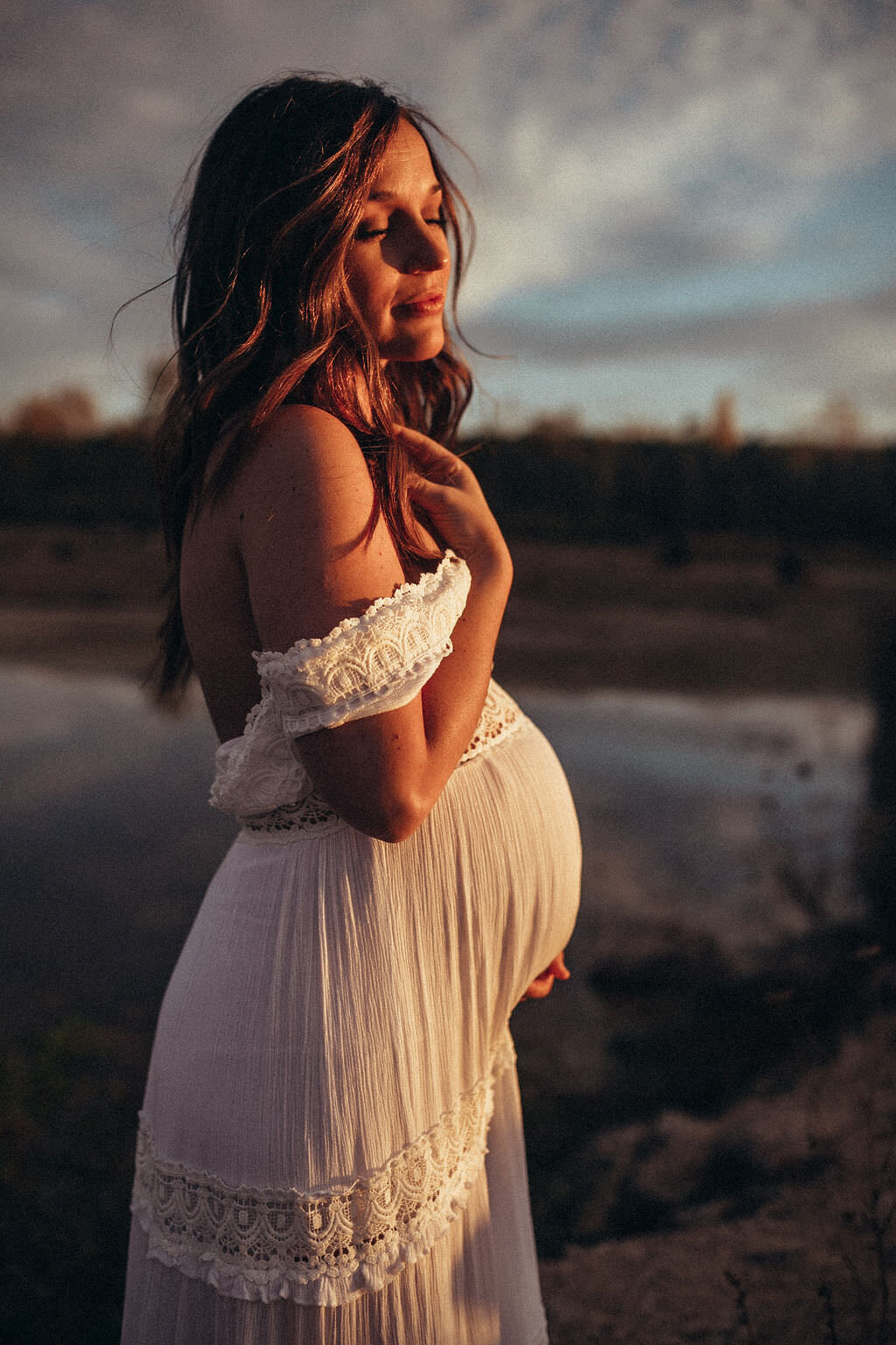 pregnant woman posing by lake