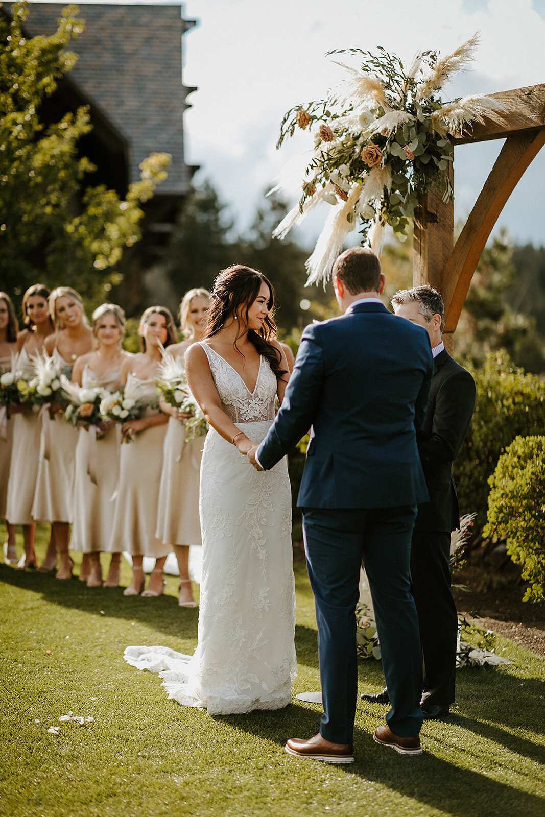 Wedding ceremony in front of Broken Top arch with pampas grass and roses at Tetherow Resort in Bend
