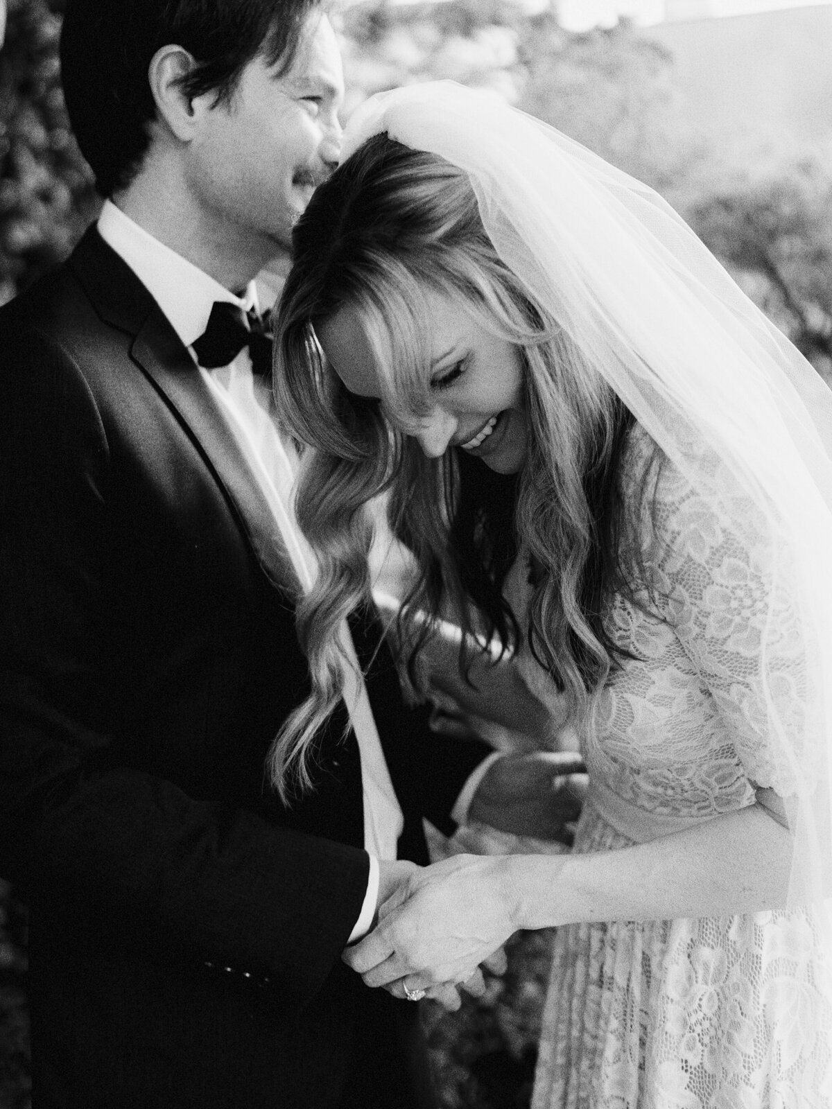 Bride and groom laughing during their garden wedding ceremony