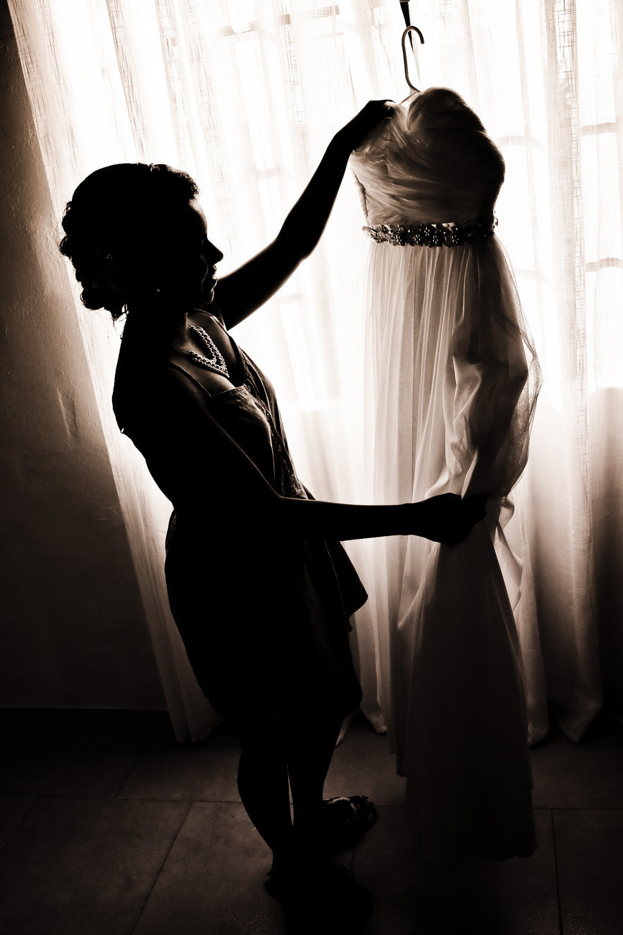 B+W silhouette of woman holding up dress. Photo by Ross Photography, Trinidad, W.I..