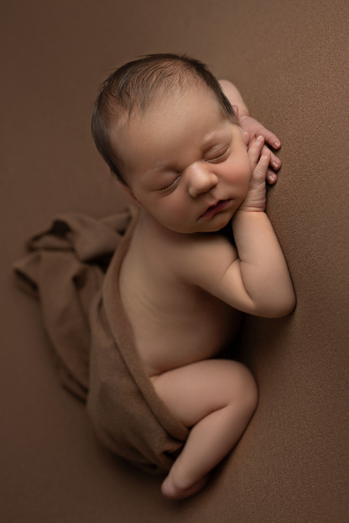 Newborn baby brown wrap classic pose Leander professional photographer