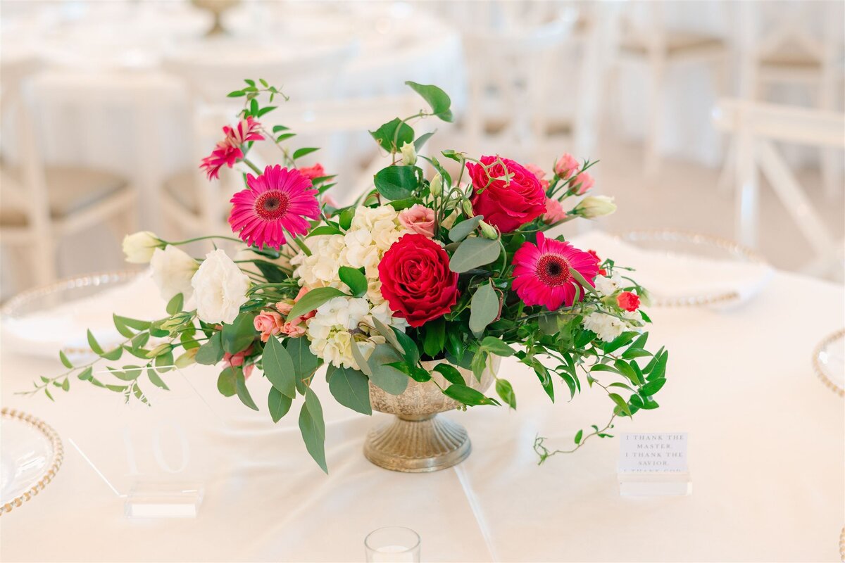 Hot pink and white flowers on thop of white tablecloths