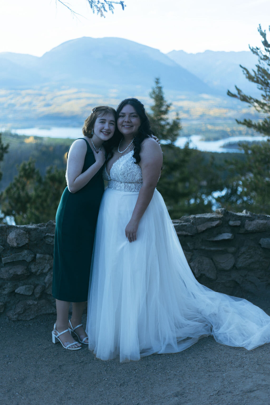 A person hugging someone in a wedding dress.