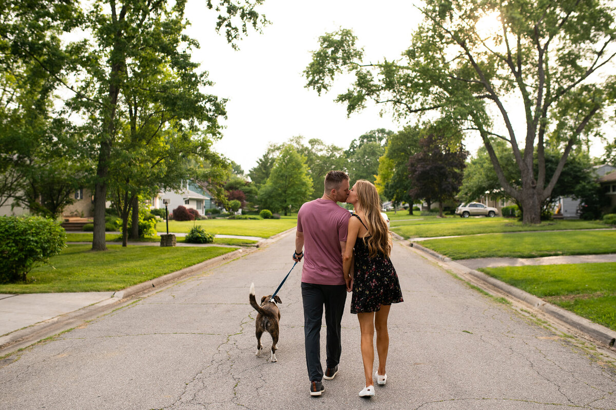 Couple takes their dog on a walk during their engagement session