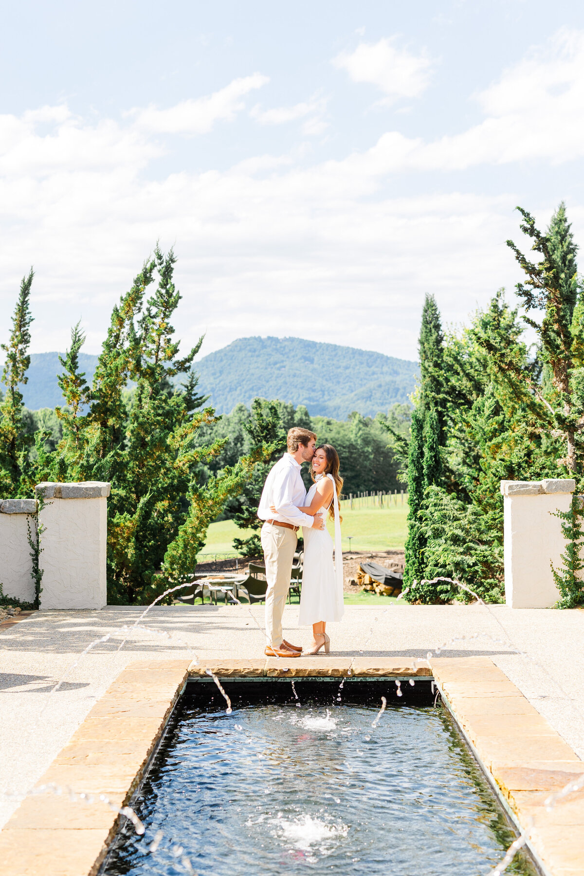 engagement session  by fountains with mountains in background at hotel domestique