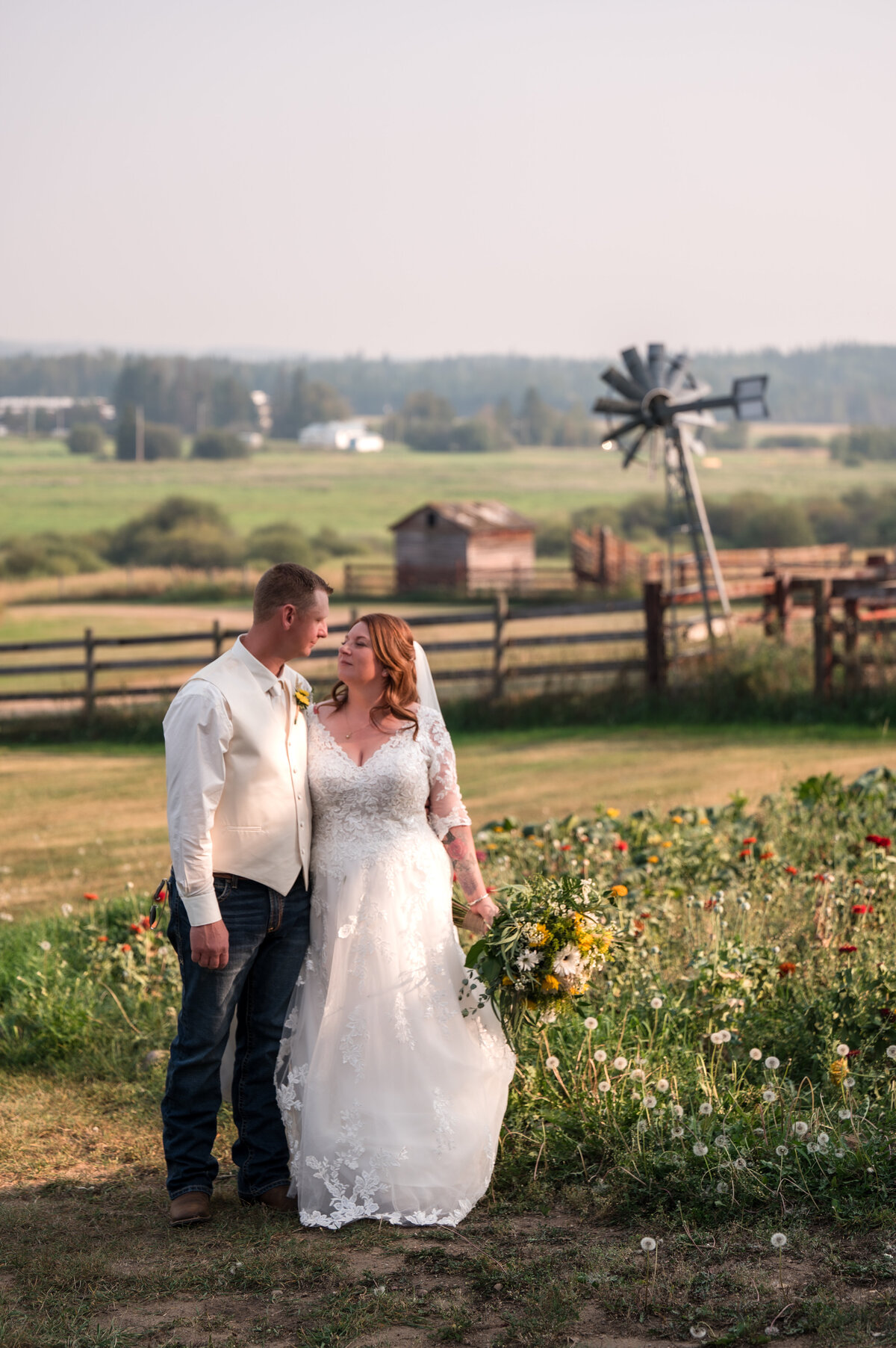 bride and groom looking at each other in the middle of a beautiful field near Athabasca