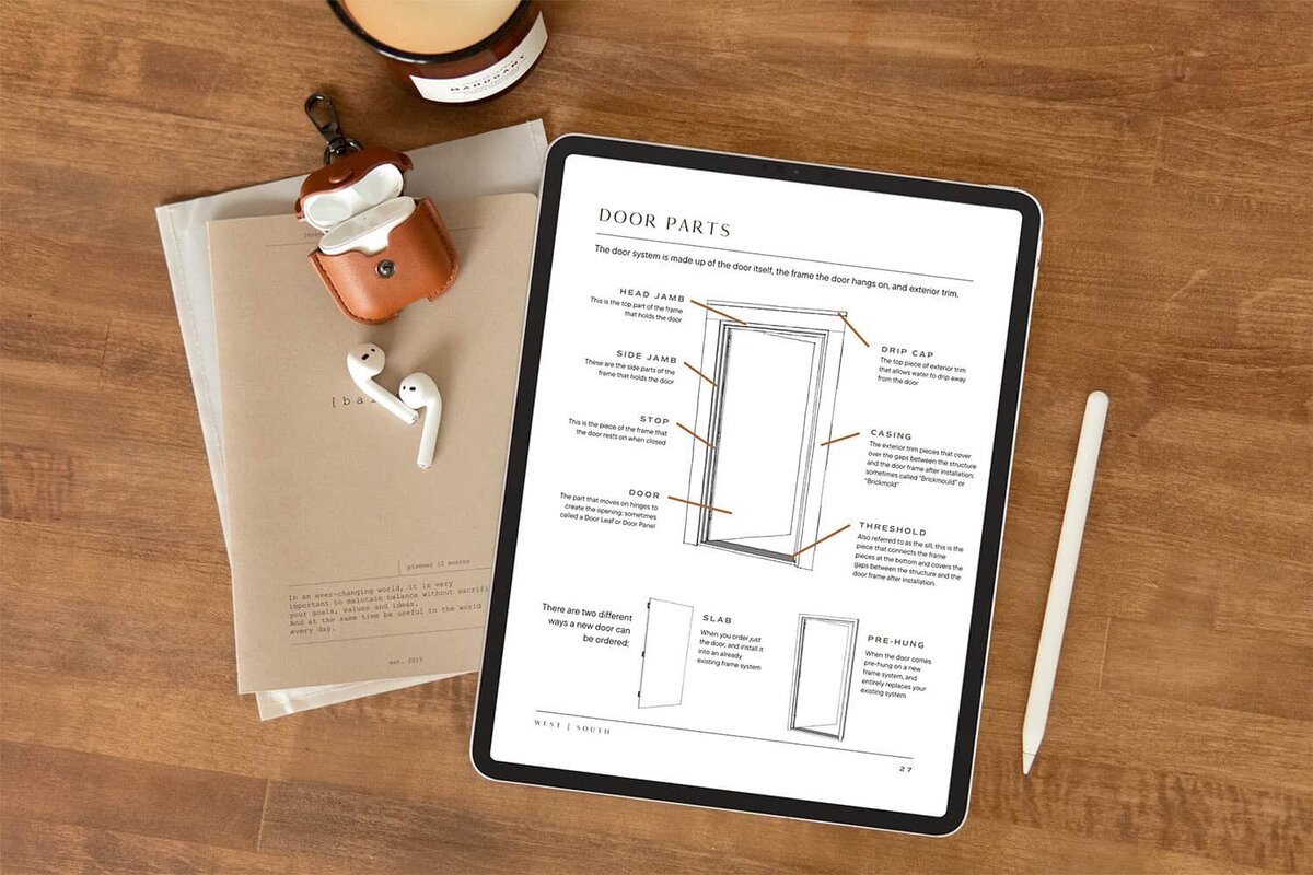 a page from Exterior House Parts Explained showing the various parts of a door on an ipad sitting on a wood desk next to ear buds in a cognac leather case