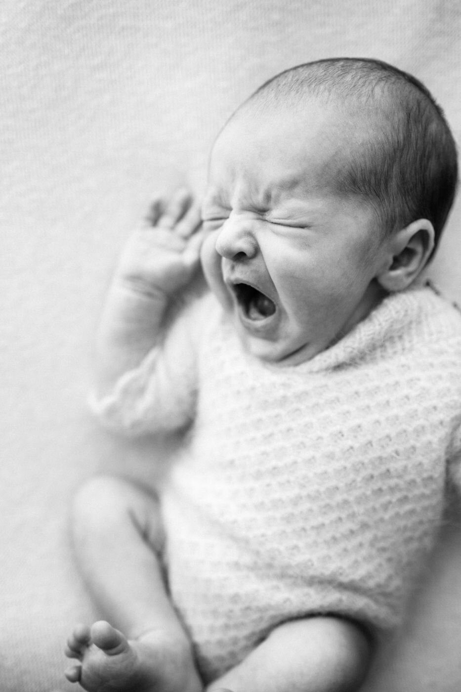 Close-up black and white photograph of a newborn baby with an open mouth in Mullingar.