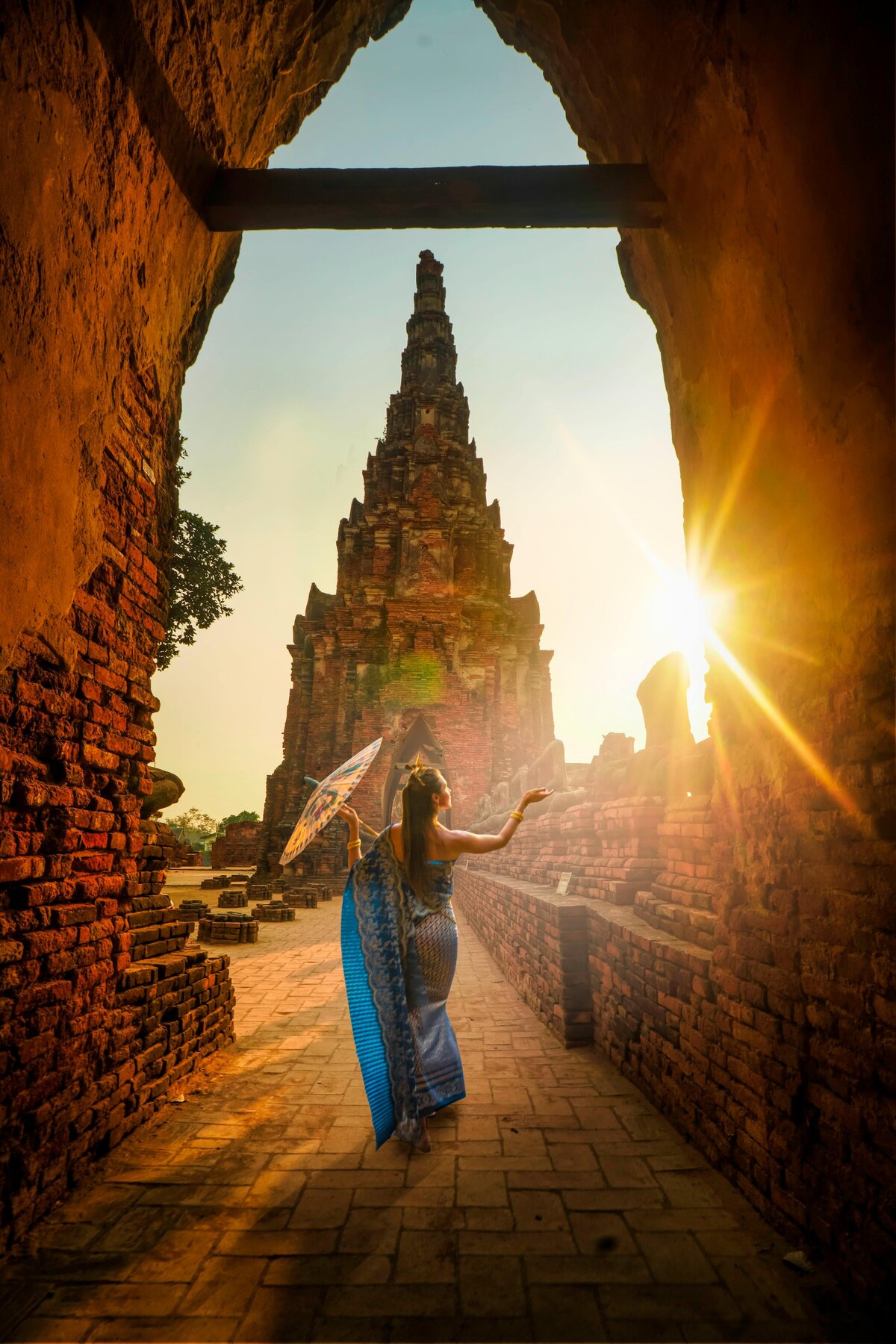 woman-traditional-attire-umbrella-ancient-temple-sunset