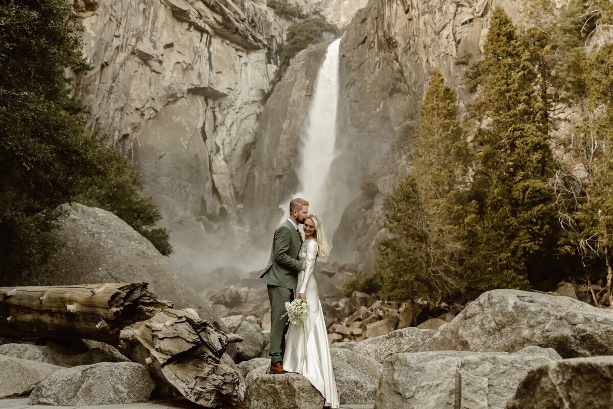 Bride and Groom posing in front of waterfall at Lake Tahoe elopement