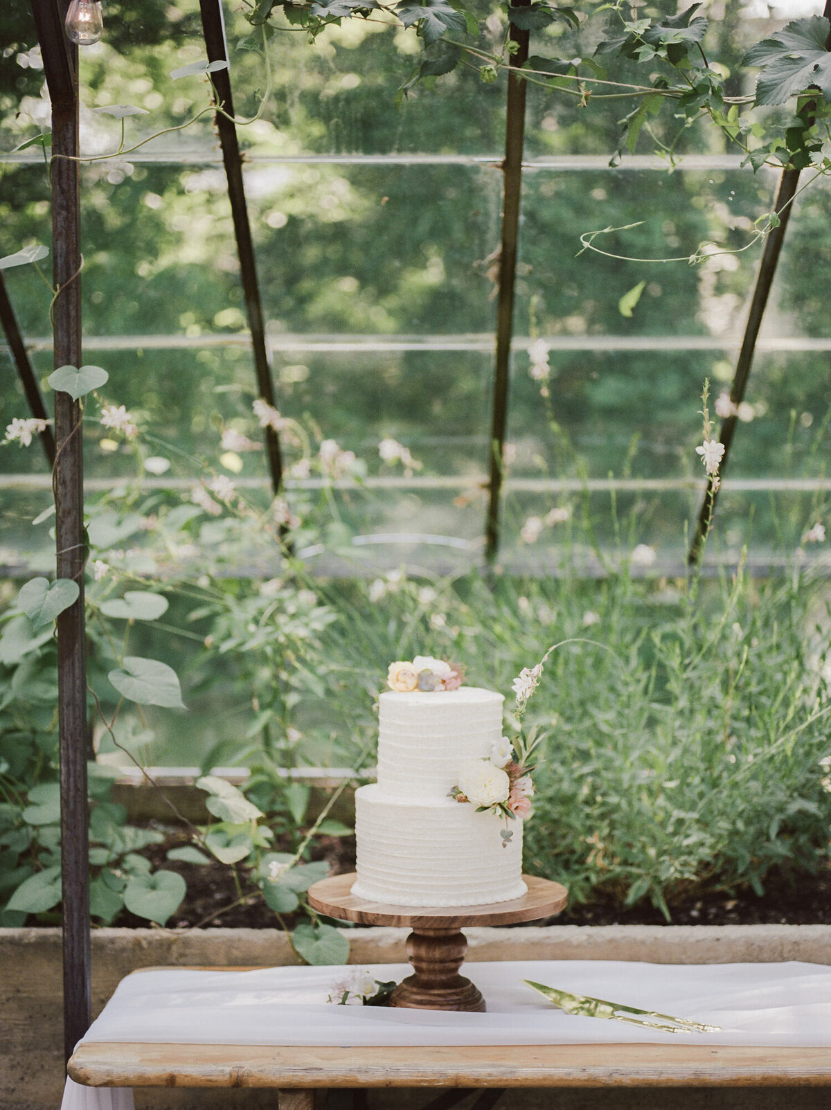 simple frosting wedding cake with flowers at glass Greenhouse wedding, Michigan