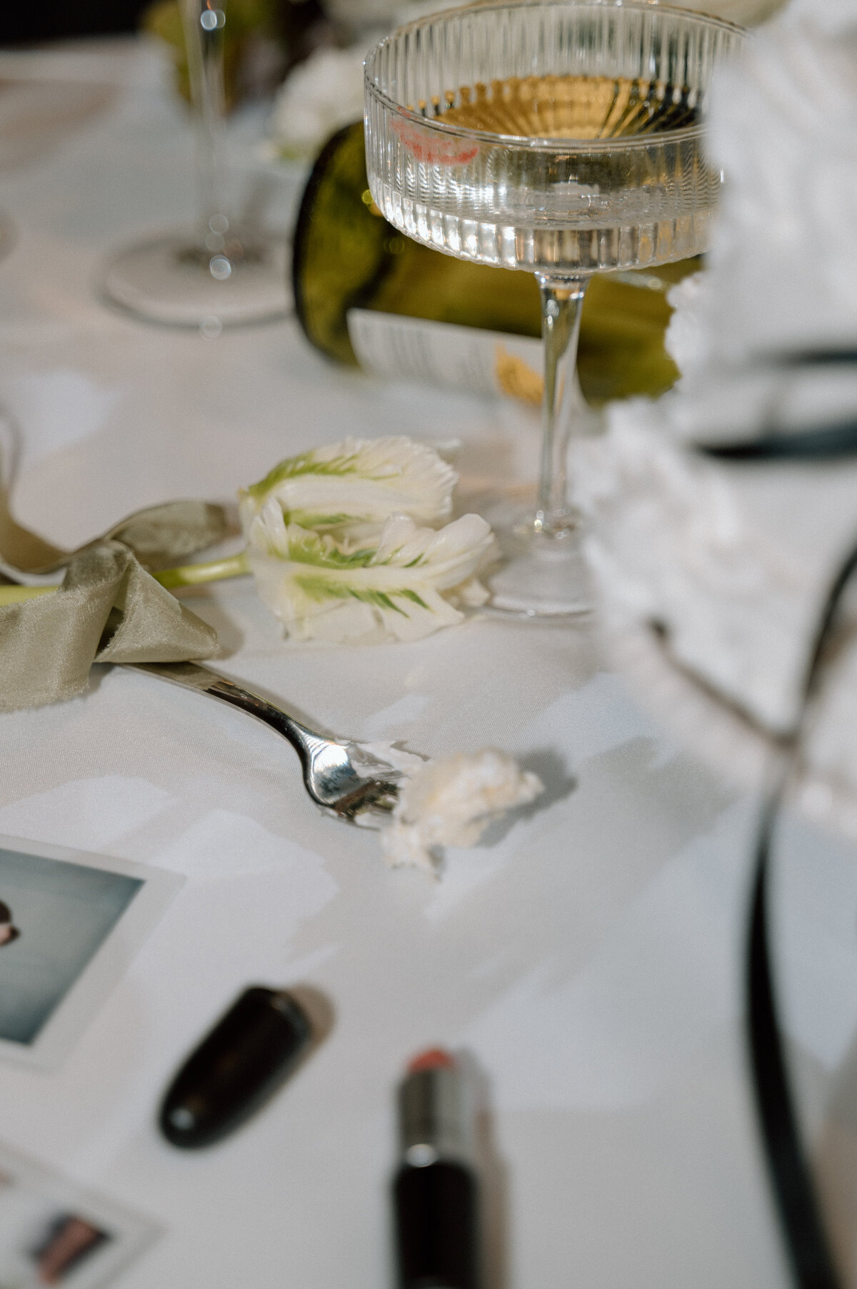 Close-up of cocktail glass with reflections of a romantic floral tablescape at Banff wedding.
