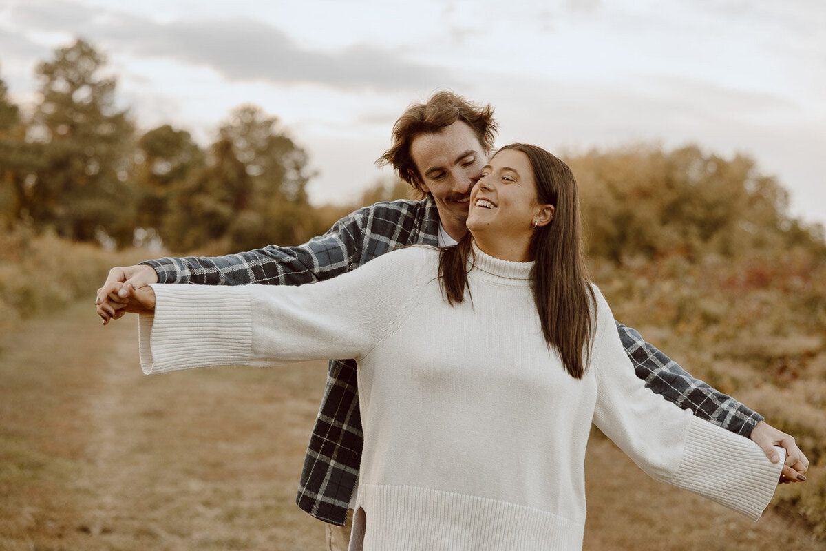 Couple does airplane pose with arms outstretched