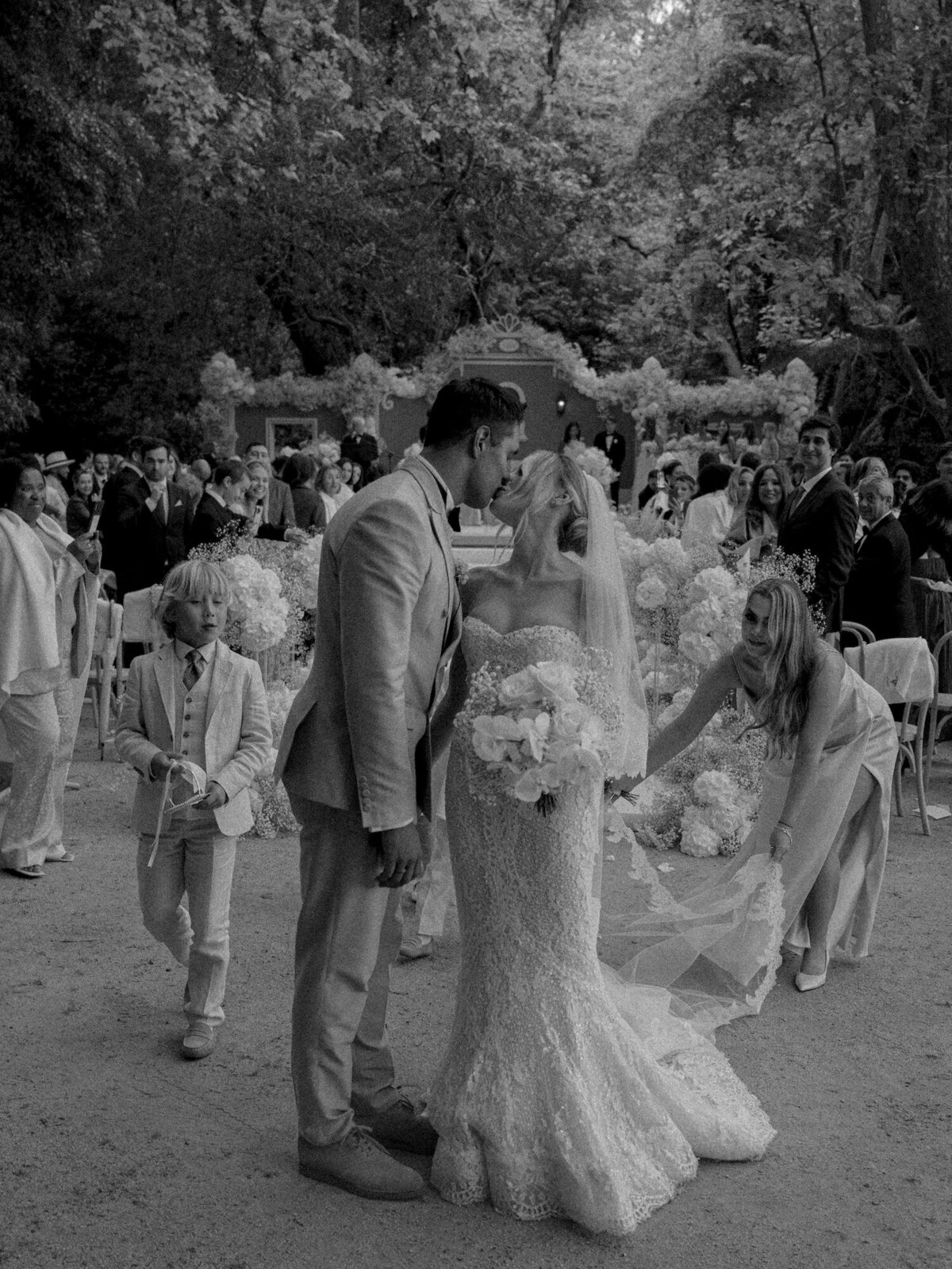A photo of a bride and a groom share a kiss at the end of their aisle exit in their Quinta da Bellavista destination wedding