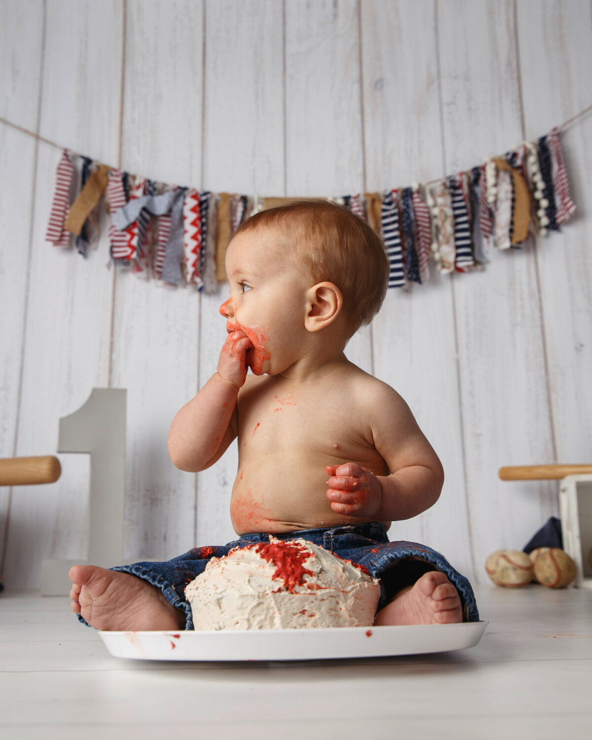 Cute one year old boy photographed with a cake for his first birthday