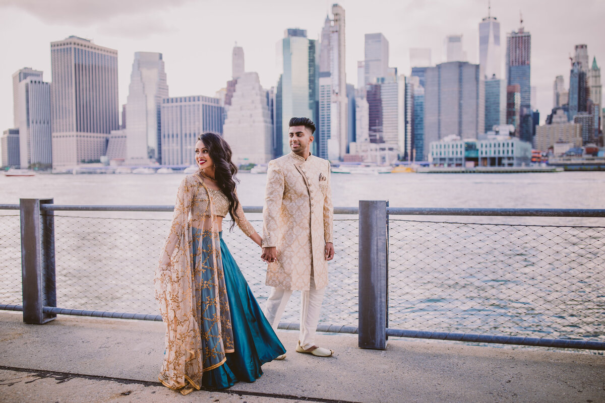 A couple in indian clothing standing by the promenade at the brooklyn bridge park in dumbo