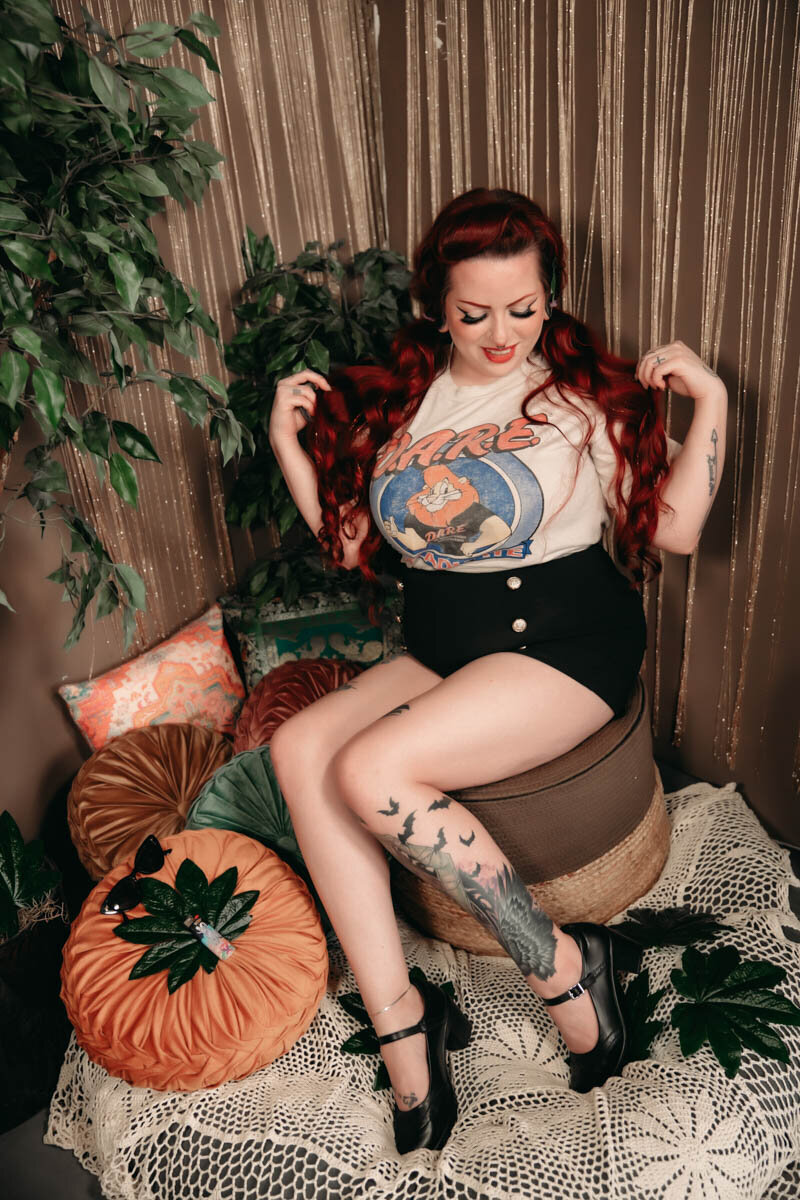 Girl sitting in a boho set  with pinup shorts and tshirt  playing with her hair