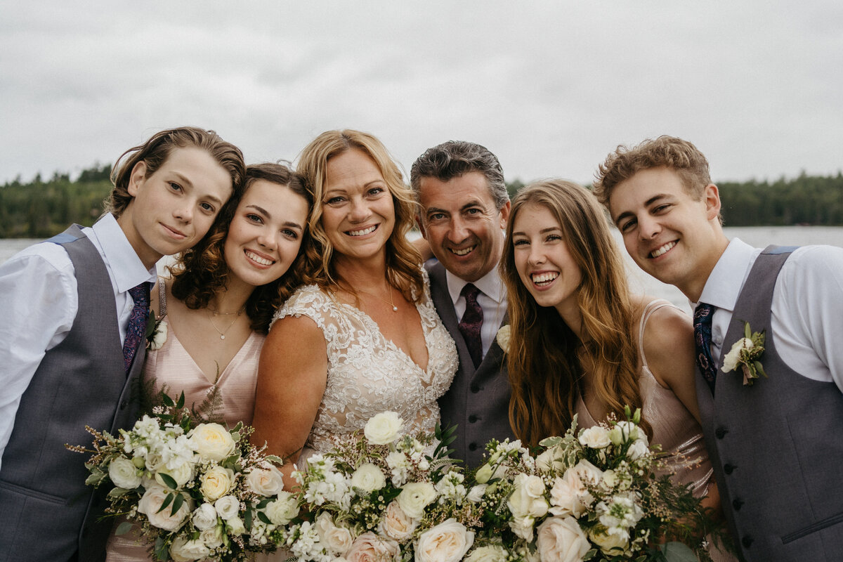 wedding party embracing by lake