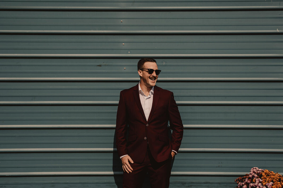 A person in a suit and sunglasses smiling 