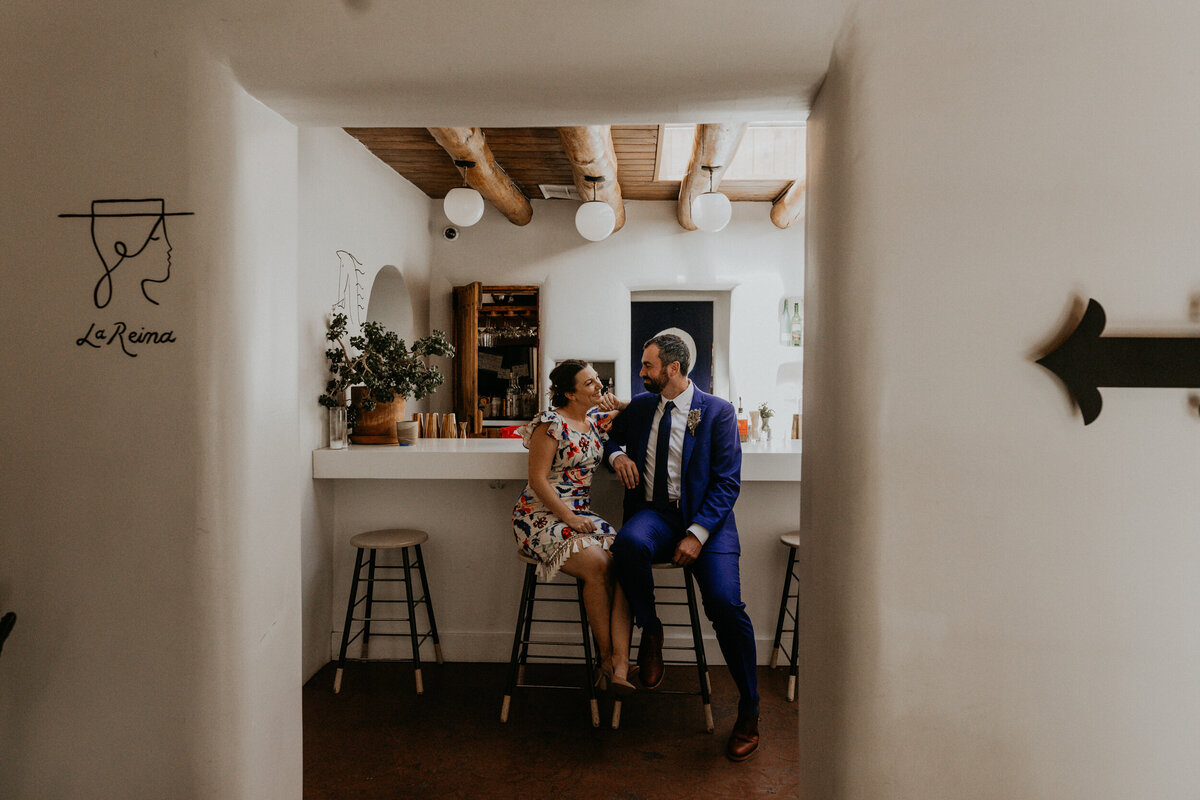 bride and groom standing together at an adobe style bar in Santa Fe