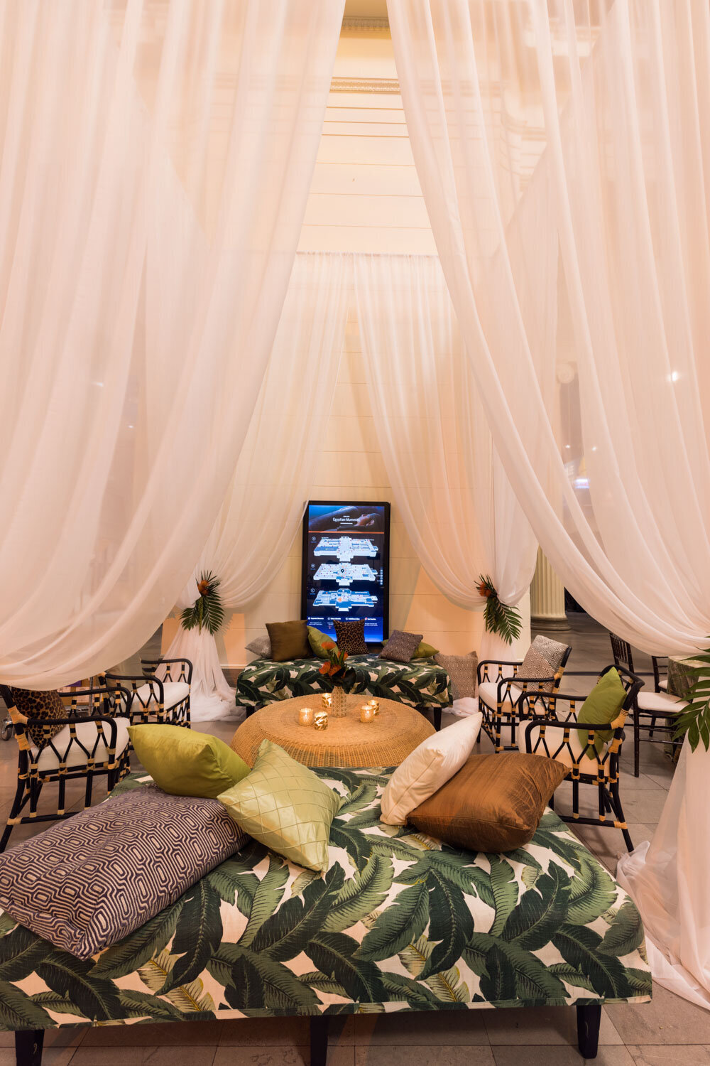 Cozy lounge with white drapes and tropical pillows