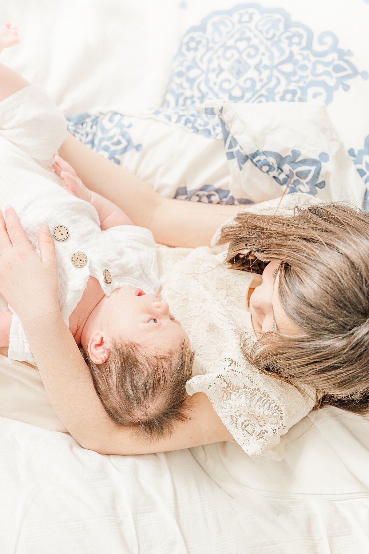 sister with baby dung in-home newborn photo session with Sara Sniderman Photography in Needham Massachusetts