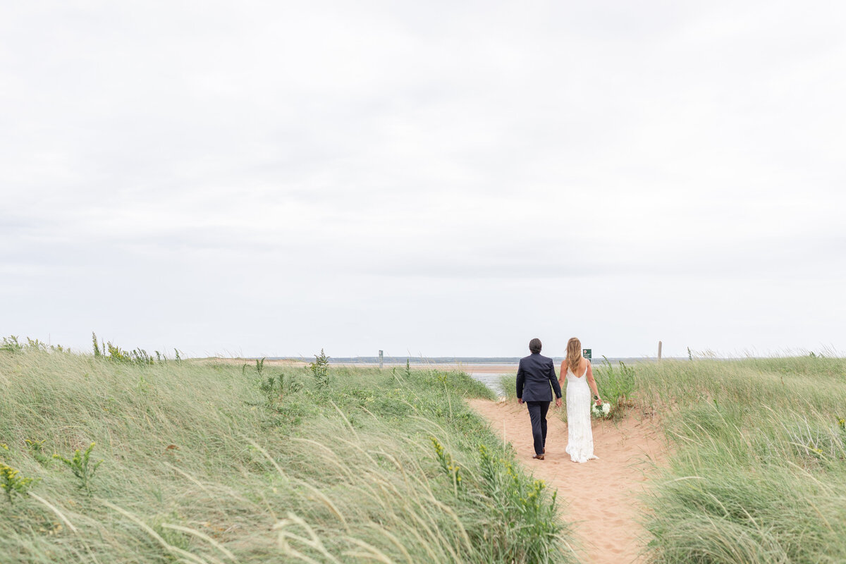 Bride and groom walking on PEI beach