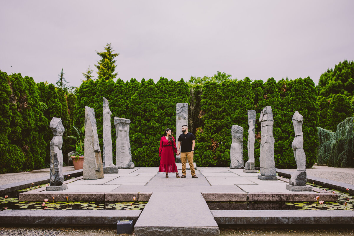 A couple standing on area called nine muses at the ground for sculpture in nj during their engagement session