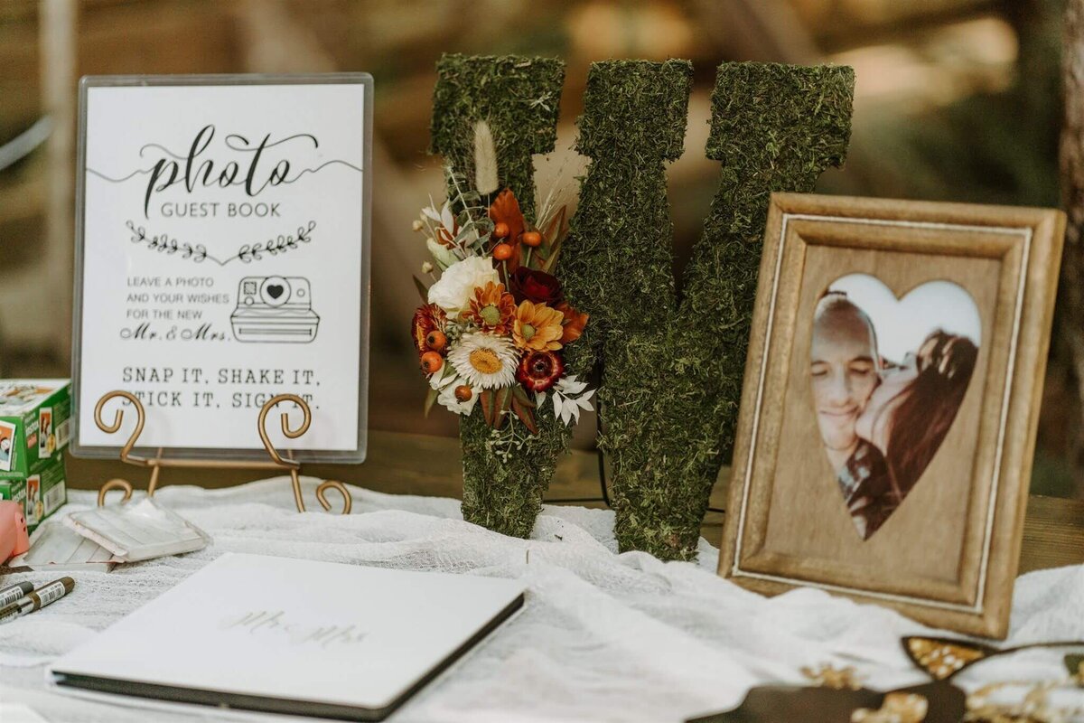 Dried flowers on a letter W made out of greenery on display at a wedding reception.