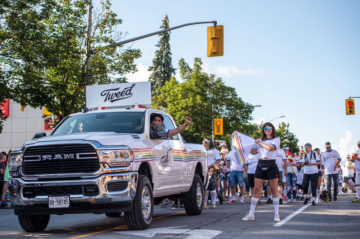 Tweed organizers of the Pride Parade driving a truck and waving a flag.  Captured by Ottawa Event Photographer JEMMAN Photography COMMERCIAL