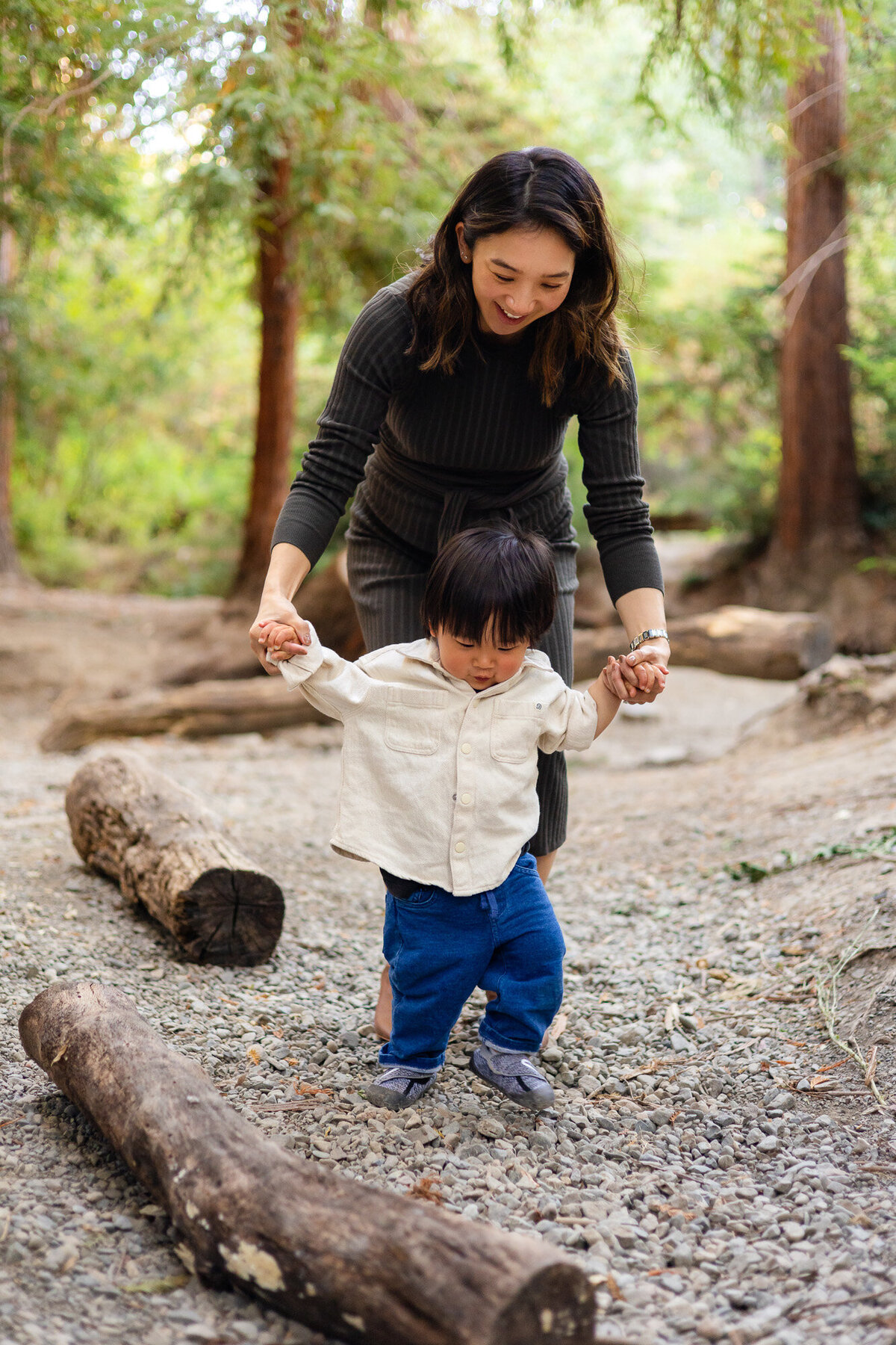 Mom helping toddler walk while holding hands on rocky forest path – Bay Area Family Portfolio | Ellobelle Photography
