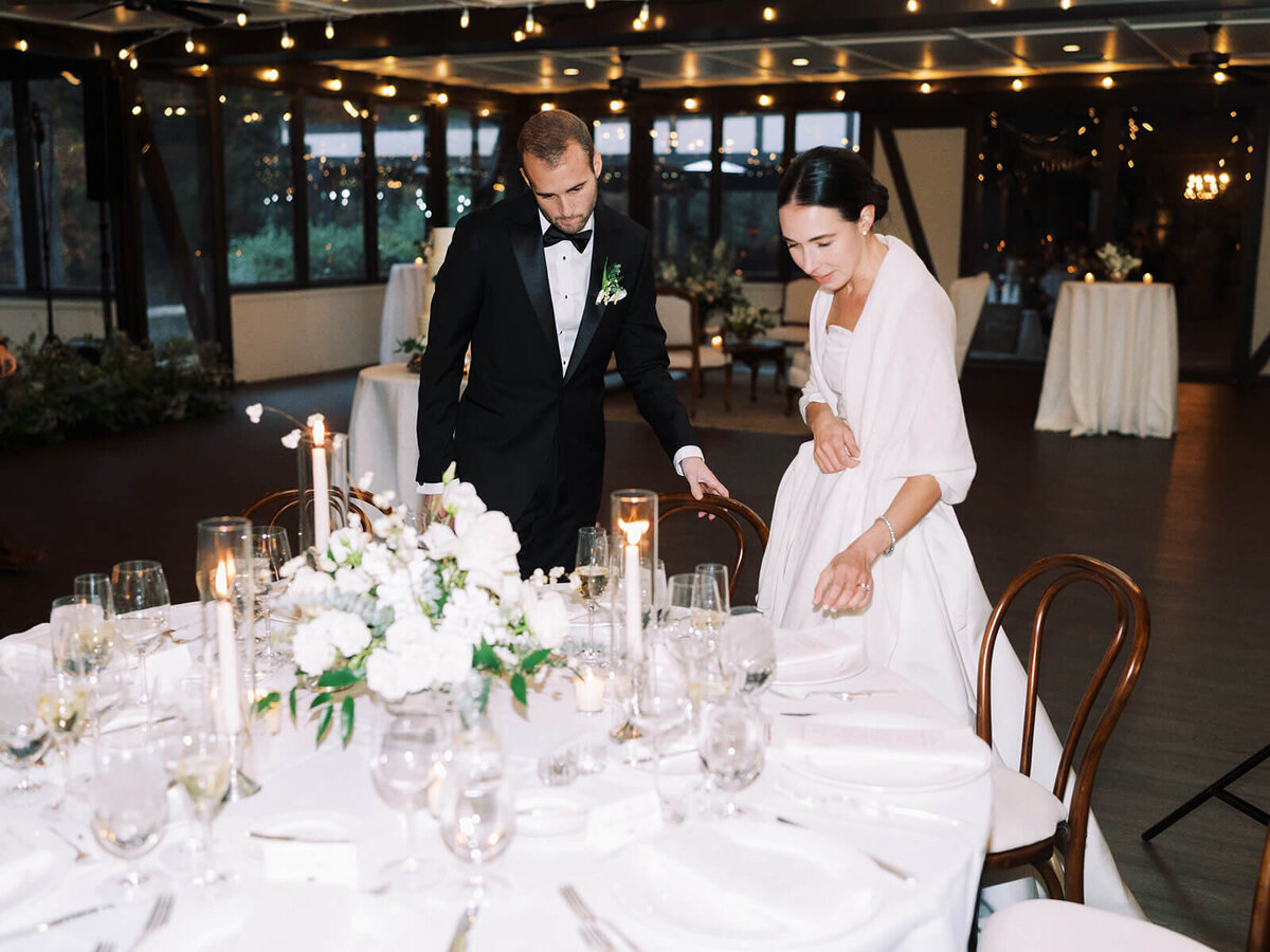 38.  bride-groom-setting-wedding-table-white-decor-candlelight