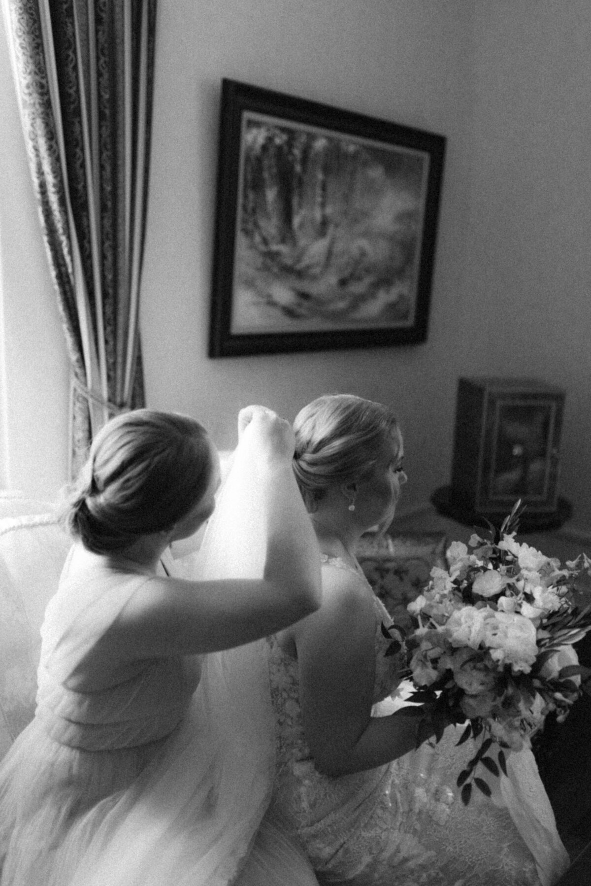 The bridesmaid helping in putting on the veil in an image photographed by wedding photographer Hannika Gabrielsson.