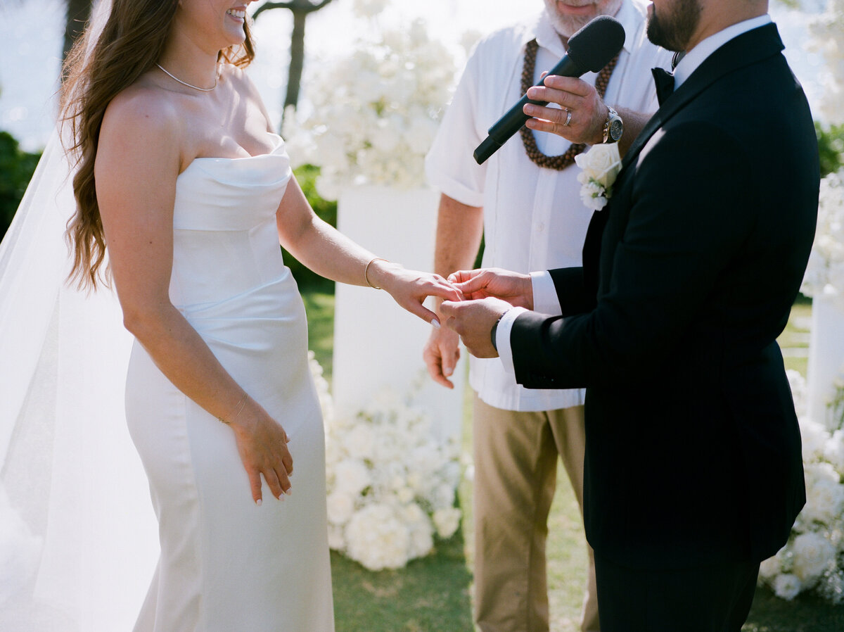 Bride and groom exchange wedding rings at the altar in a heartfelt ceremony moment — by Kate Winters Photography.